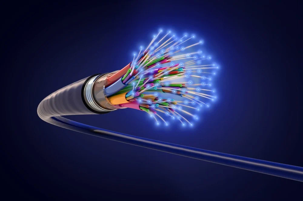 Glowing fiber optic cable bundle transmitting light signals