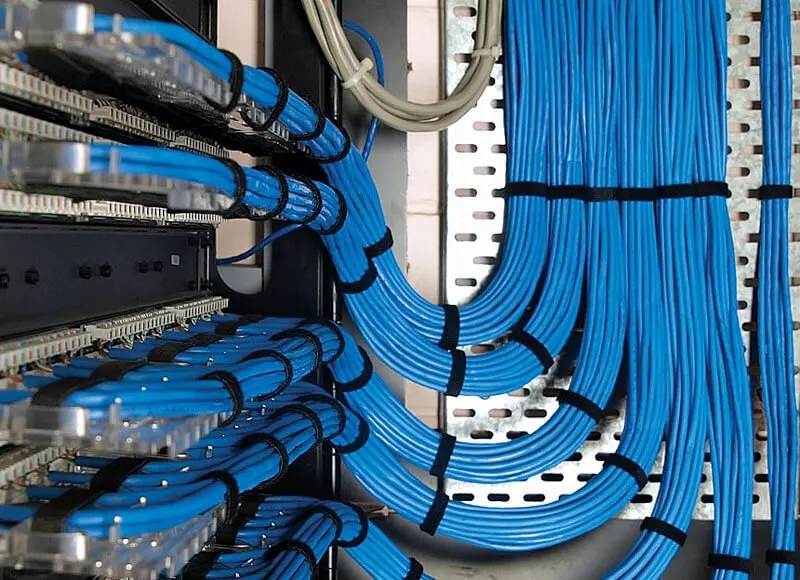 Structured cabling Dubai cable management with blue cables routed to a patch panel